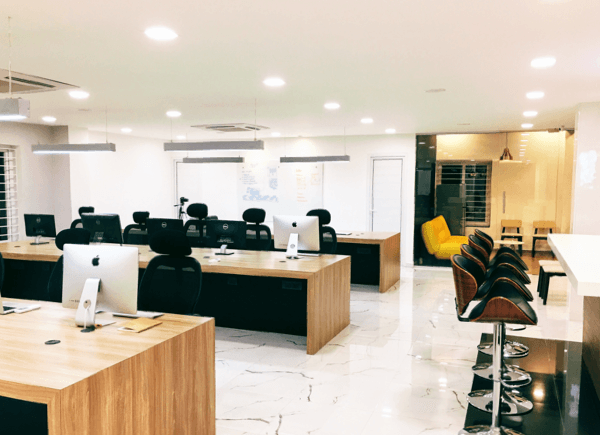 Open office workspace with multiple workstations, iMac computers, and modern ergonomic chairs in bright interior Open office workspace with multiple workstations, iMac computers, and modern ergonomic chairs in bright interior